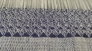 Woven fabric with triangle motifs generated by an unseen algorithm.